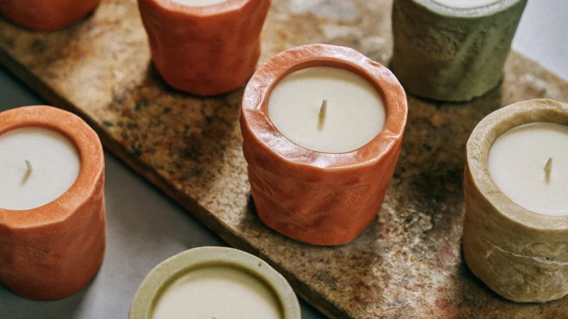 Bougies colonnes sculptées en terracotta, sable et sauge sur une dalle de pierre
